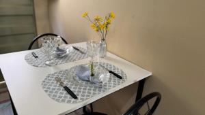 a white table with glasses and a vase with yellow flowers at Casa Mobiliada com 4 camas e 2 quartos in Juazeiro do Norte +22 photos