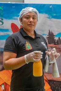 eine Frau hält eine Flasche Orangensaft in der Unterkunft GS Hoteles-Cajamarca in Cajamarca