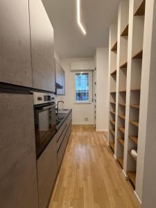 a kitchen with stainless steel appliances and wooden shelves at Chic Loft in Porta Venezia in Milan