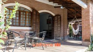un patio con sillas, una mesa y una hamaca en Chacara em Monte Sião com Piscina e Lazer Completo, en Monte Sião