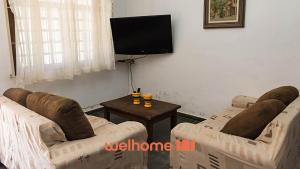 Una sala de estar con dos sofás y un televisor de pantalla plana. en Chacara em Monte Sião com Piscina e Lazer Completo, en Monte Sião 25 fotos más