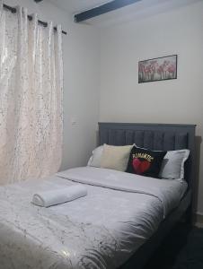 een bed met witte lakens en kussens in een slaapkamer bij Cozy Homes Kitengela in Nairobi