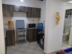een kleine keuken met een fornuis en een magnetron bij Cozy Homes Kitengela in Nairobi