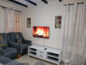 een woonkamer met een open haard aan de muur bij Cozy Homes Kitengela in Nairobi