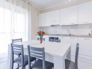 a white kitchen with a white table and chairs at Casa Bellavista in SantʼAntonio Abate