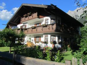 a house with a balcony in the mountains at Landhaus Sailer in Mittenwald