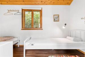a white room with a bed and a window at 4720-Ronne-Stampen-Vej-2-Hus-18 in Rønne