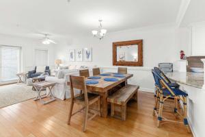 a dining room and living room with a table and chairs at Brass Rail 106 in Tybee Island