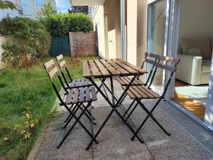 two wooden chairs and a picnic table on a patio at Charming 3 rooms with parking in Rueil-Malmaison