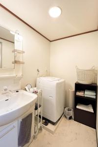 a bathroom with a sink and a refrigerator at Wisteria102 無料駐車場有 JR春日井駅徒歩3分の宿 in Kasugai