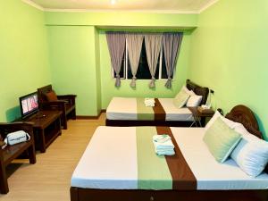 a hotel room with two beds and a television at Albergo Hotel - Studio Condo Unit - Baguio Transient in Baguio