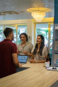 a group of people standing around a table with a laptop at Hotel Atlantic in Giulianova