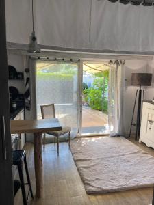 a living room with a table and a sliding glass door at Le Studio de Sosso in Aniane