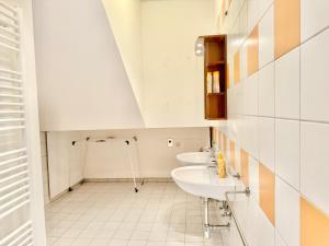 2 wastafels in een badkamer met witte tegels bij Luxury 130 m2 Apartment with Garden in Wenen