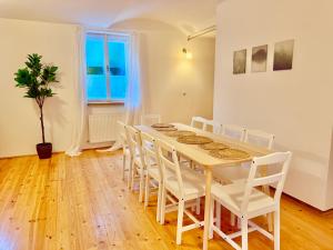 een eetkamer met een tafel en witte stoelen bij Luxury 130 m2 Apartment with Garden in Wenen +22 foto's