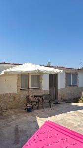 eine Terrasse mit einem weißen Regenschirm und einem Tisch in der Unterkunft Casinha no coração do Oeste in Cadaval + 24 Fotos