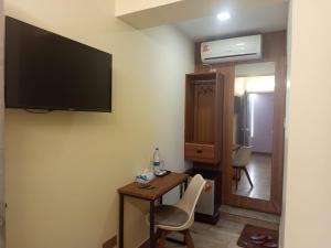 a room with a table and a television on the wall at Grand Imperial Hotel in Chittagong