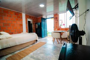 a bedroom with a bed and a table and a desk at GREEN APARTMENT "el bosque" in Girón