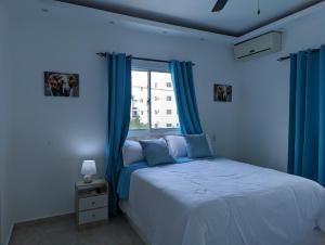 ein blaues Schlafzimmer mit einem Bett und einem Fenster in der Unterkunft Azure Breeze Hotel in Bayahibe + 31 Fotos
