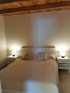 een slaapkamer met een wit bed met twee lampen erop bij Casa El Alpendre de Temisas - Recién renovada in Temisas