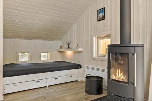ein Schlafzimmer mit einem Bett und einem Kamin in der Unterkunft 2652 Nexø - Væbnerstien 5 in Neksø