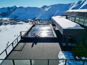 una piscina in cima a una montagna innevata di Ski In Ski Out Tiamo apartment 402 at Gudauri Loft Hotel a Gudauri