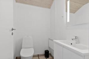 ein weißes Badezimmer mit Toilette und Waschbecken in der Unterkunft 2652 Nexø - Væbnerstien 5 in Neksø + 15 Fotos