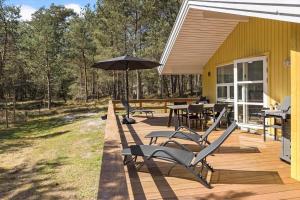 eine Terrasse mit Stühlen und einem Sonnenschirm an einem Haus in der Unterkunft 2652 Nexø - Væbnerstien 5 in Neksø
