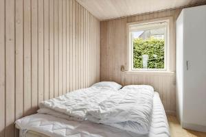 un letto bianco in una stanza con una finestra di 6681-Allinge-Brunekulvej-2-G ad Allinge
