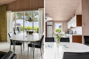 una cucina e una sala da pranzo con tavolo e sedie di 6681-Allinge-Brunekulvej-2-G ad Allinge