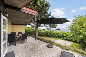 un patio con un tavolo e un ombrellone di 6681-Allinge-Brunekulvej-2-G ad Allinge Altre 11 foto