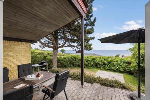 un patio con un tavolo e un ombrellone di 6681-Allinge-Brunekulvej-2-G ad Allinge