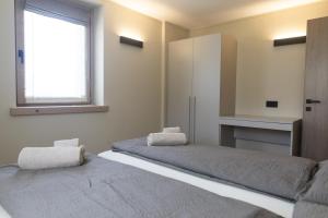 een slaapkamer met twee bedden en een raam bij Baita della Valle -Appartamento Bucaneve- in Livigno