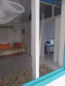 een kamer met een stapelbed en een slaapkamer met een bank bij ALAMANDA le grand palm in Grand-Bourg