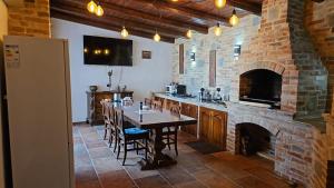 a kitchen with a table and a brick fireplace at Ale&Sere Housing in Jiblea Nouă
