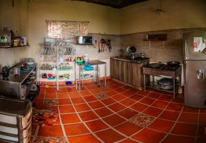 a kitchen with a red tile floor and a refrigerator at GREEN APARTMENT "El Jardín" in Girón