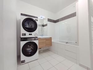a washing machine in a bathroom with a tub at Charming 3 rooms with parking in Rueil-Malmaison +2 photos
