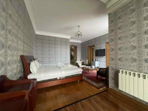 a bedroom with a bed and a desk and a chair at hotel amber in Batumi