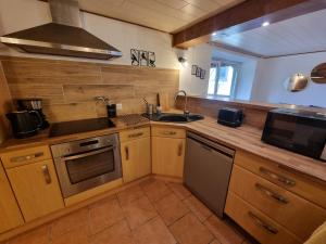 eine Küche mit Spüle und Herd oberen Backofen in der Unterkunft NOUVEAU Gite Le Geai Bleu a 5min de La Petite Pierre Terrasse couverte et jardin in Erckartswiller