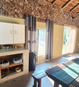 a kitchen with a table in a room with windows at Hide Away Wedding,Conference & Function Venue in Bela-Bela
