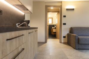 een keuken met een wastafel en een bank in een kamer bij Baita della Valle -Appartamento Bucaneve- in Livigno +3 foto's