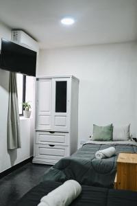 a bedroom with a bed and a dresser with a television at Habitaciones Temporarias CABA in Buenos Aires