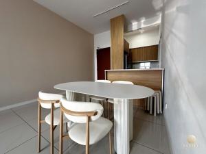 una cocina con una mesa blanca y algunos taburetes en NEW Le Pavilion Puchong 8-10pax 3R2B, en Puchong