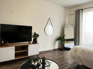 a living room with a flat screen tv and a bed at High Rise Haven in Johannesburg