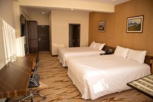 a hotel room with two beds and a desk at CAR Sport Hotel Titikaka in Huarina +22 photos