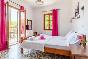 a bedroom with a bed with pink towels on it at Fotini Rooms in Skopelos Town +16 photos