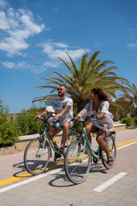 a man and woman riding bikes down a street at Hotel Atlantic in Giulianova