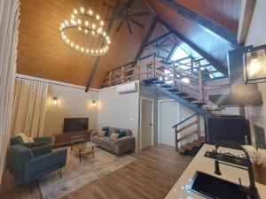a living room with a staircase and a couch and a television at Cabañas Piedra del Risco in Alto Boquete