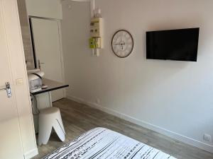 a bedroom with a bed and a clock on the wall at Studio Zen - Paris à 5mn in Alfortville
