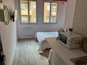 a room with a bed and a microwave on a counter at Studio Zen - Paris à 5mn in Alfortville